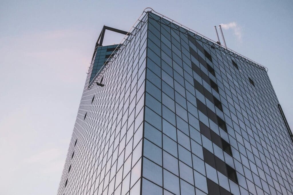 Low angle view of a modern glass office building in Tallinn, Estonia against a clear sky.