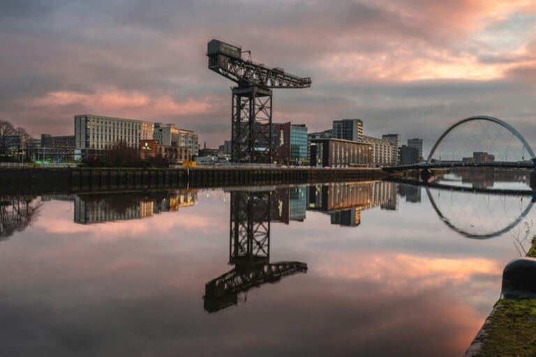 Stunning sunset view of Glasgow's River Clyde, featuring iconic structures and reflections.